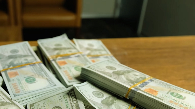 Stacks of Hundred-Dollar Bills Placed on A Wooden Table