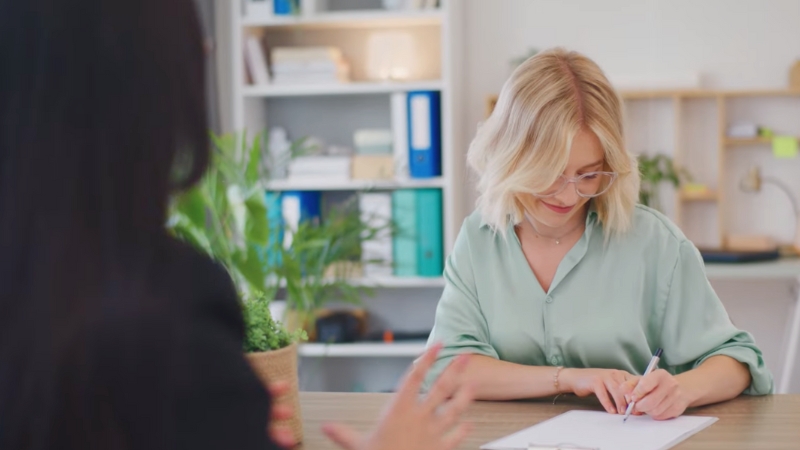 A Woman in An Office Signing a Document 