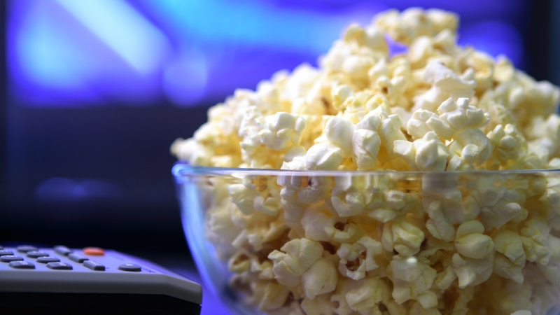 A bowl of popcorn with a remote control, ready for a cozy movie night on Mother’s Day