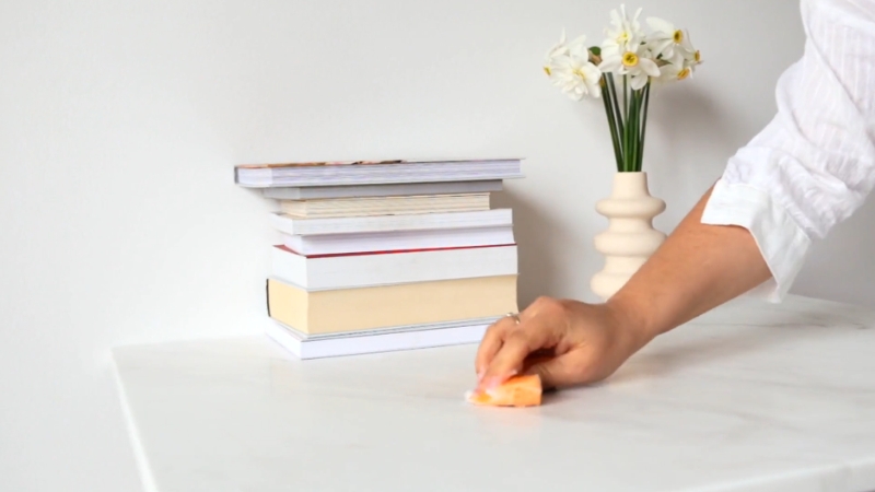 A person cleaning a surface as part of a thoughtful Mother’s Day chore surprise