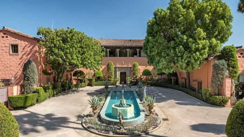 The Beverly Estate has a large courtyard with a long fountain and trimmed trees