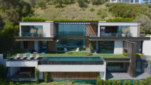 One of the top celebrity mansions, this modern hillside home features floor-to-ceiling glass, sleek lines, and a luxury infinity pool
