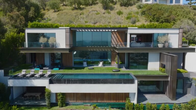 One of the top celebrity mansions, this modern hillside home features floor-to-ceiling glass, sleek lines, and a luxury infinity pool