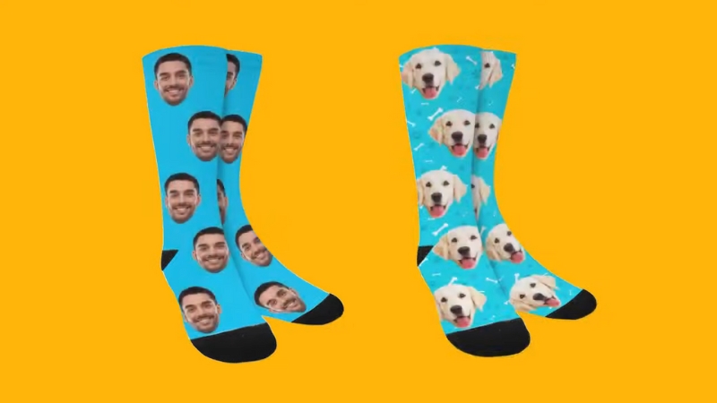 Two pairs of blue socks printed with repeating faces—one with a smiling man and the other with a happy dog