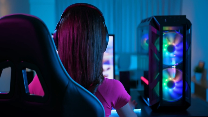 Girl at a gaming setup with RGB lights, showing how players interact with traditional NPC behavior in games