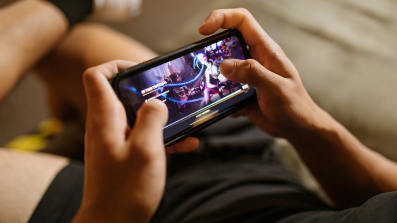 Person playing a video game on a smartphone through cloud streaming