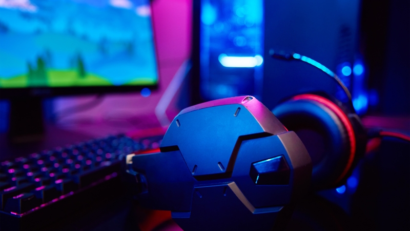 High-end gaming PC setup with monitor, keyboard, and headset under neon lighting