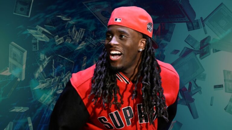 Kai Cenat wearing a red Supreme jacket and cap, smiling with dollar bills in the background