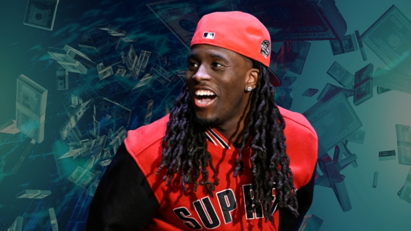 Kai Cenat wearing a red Supreme jacket and cap, smiling with dollar bills in the background