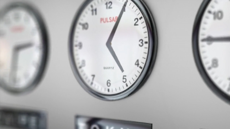 Wall clocks showing different times, representing states debating changes to daylight saving time