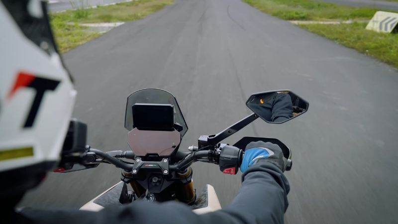 A rider controls an electric motorcycle on an open road