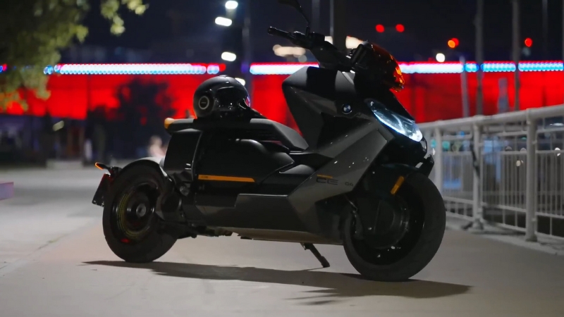 BMW CE 04 electric scooter parked at night near a railing