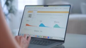A person reviews sales charts on a laptop to track performance for Etsy Shops