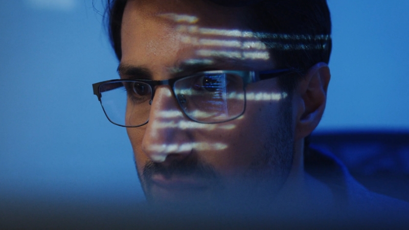A focused software engineer reviews code on his screen