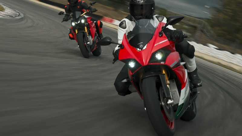 Two riders lean through a track corner on Energica electric sport motorcycles