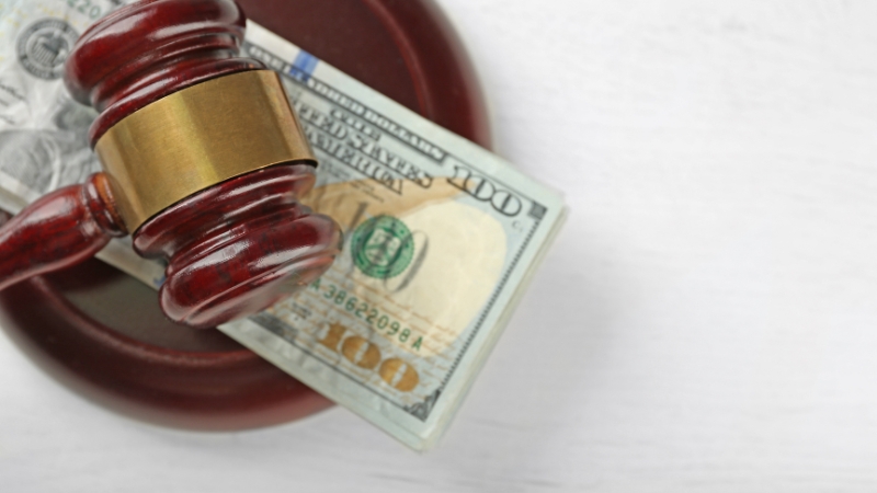 A judge’s gavel rests on U.S. dollar bills, symbolizing penalties for ignoring KYC obligations in the United States
