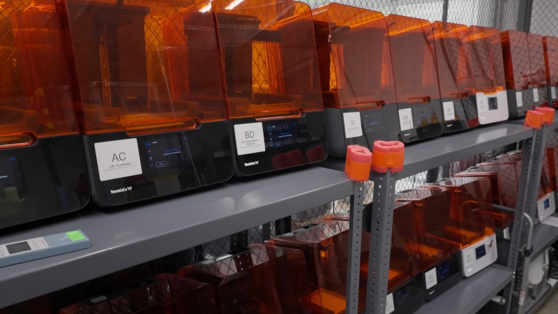 Rows of medical 3D printers sit on shelves, ready to produce customized prosthetics and parts for patient care
