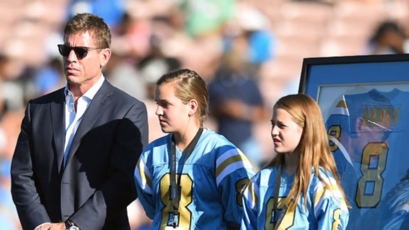 Troy Aikman stands with his daughters on the field