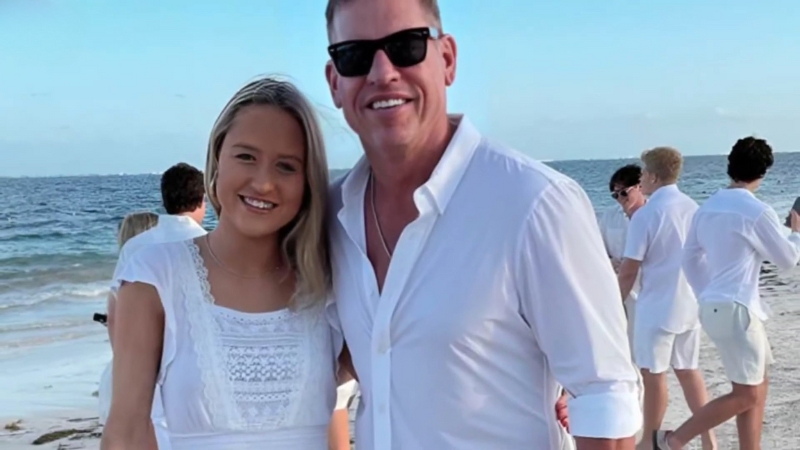 Alexa Marie Aikman stands with Troy Aikman on a beach