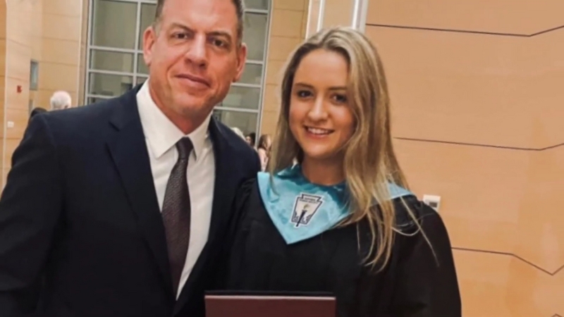 Alexa Marie Aikman stands beside Troy Aikman at her graduation ceremony