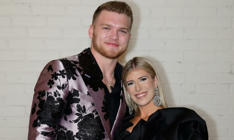 Alivia Callaghan and Aidan Hutchinson, standing side by side, smiling at the camera