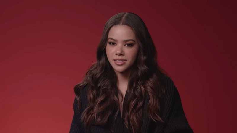 Antonia Gentry sitting in front of a red background, speaking directly to the camera