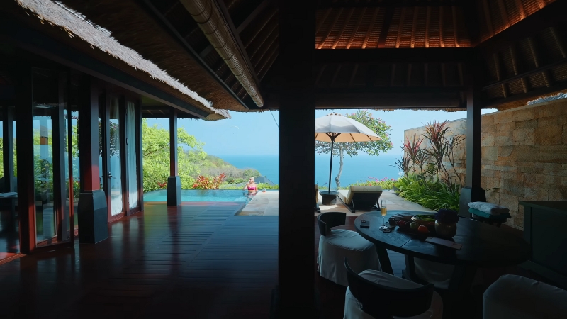 A villa view at Bvlgari Resort Bali featuring an outdoor pool, ocean scenery, and shaded seating areas