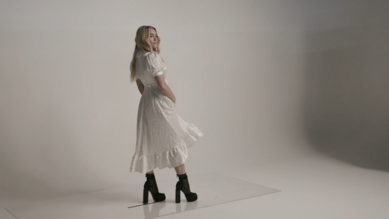 Florence Pugh poses in a white dress and black heels during a studio photoshoot