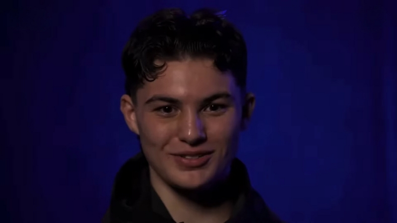 Javon Walton smiles during an interview against a dark blue backdrop