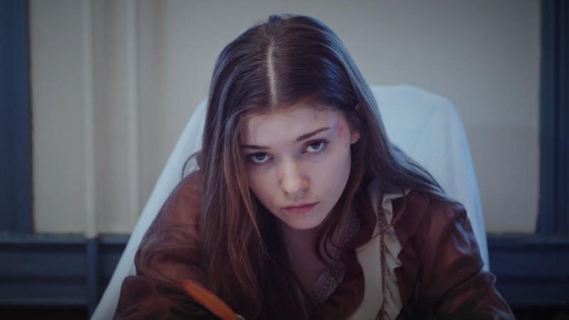 Katie Douglas appears bruised and serious in a period-style costume