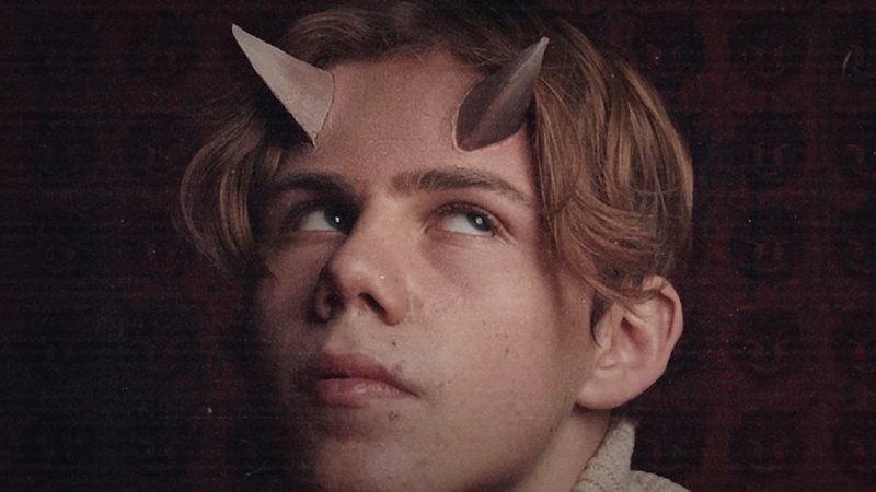 Kid Laroi looks upward in a close-up portrait with artistic horn details