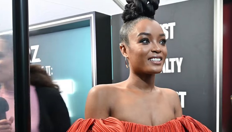 LaToya Tonodeo smiles while wearing a vibrant orange dress