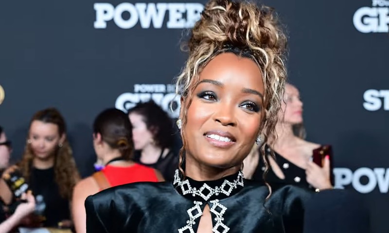 LaToya Tonodeo wearing a black dress and black top, posing confidently