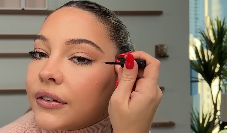 Madelyn Cline applies mascara to her eyelashes