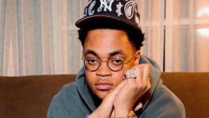 Michael Rainey Jr. sitting casually with glasses and jewelry