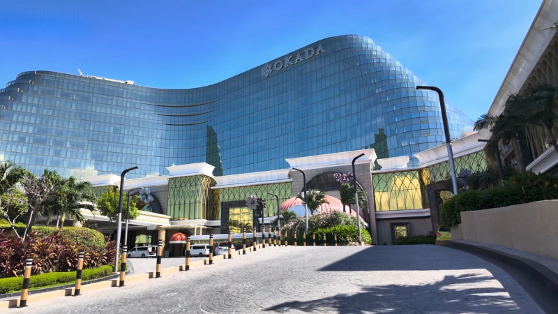 A front view of the Okada Manila resort with its glass facade and entrance