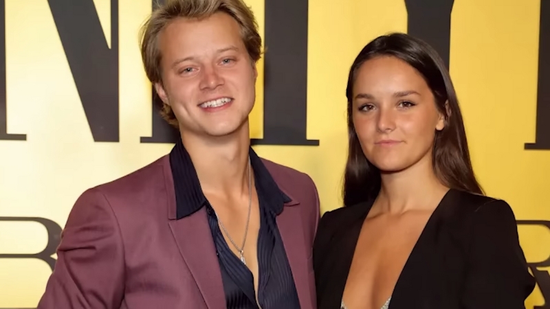 Rudy Pankow stands beside a woman at an event