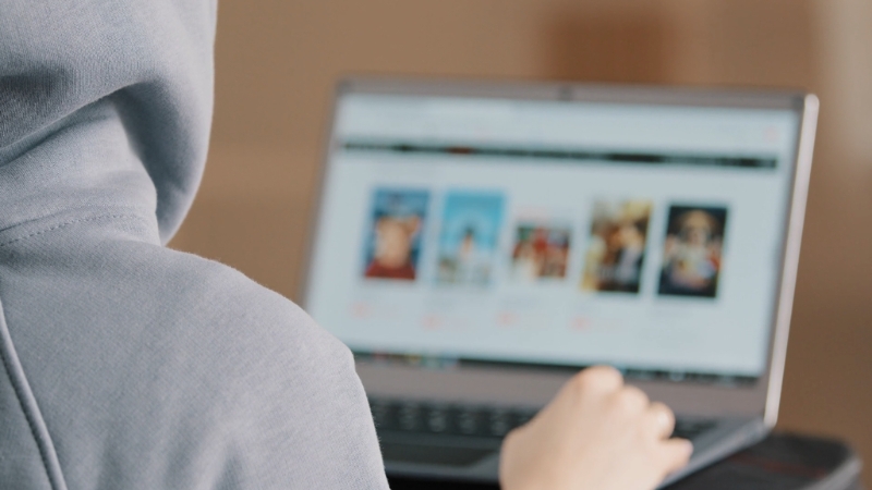A person browsing a website and responding quickly to messages on a laptop