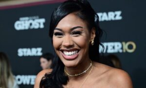 Sydney Winbush smiles brightly while posing on the red carpet at a glamorous event