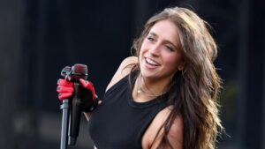 Tate McRae performs on stage with a black microphone