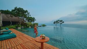 A woman stands by an infinity pool overlooking the ocean at one of the top luxury resorts in Southeast Asia