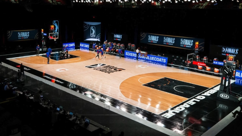 Players warm up on an NBA court with league branding before a game