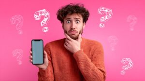 Confused man holding a smartphone with question marks around him