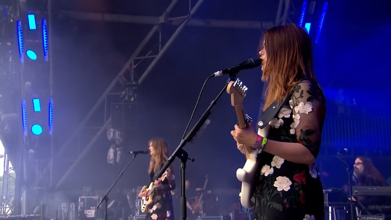 Johanna and Klara Sรถderberg perform live on stage with guitars and microphones