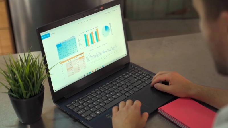 Person reviews spend analytics charts on a laptop at a desk