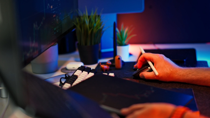 A person works on a computer analyzing spend analytics data on screen