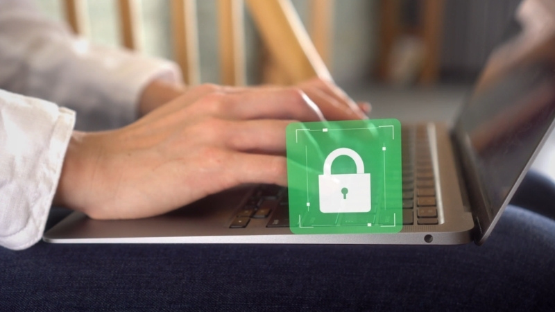 A person types on a laptop as a lock icon shows secure encrypted network communication