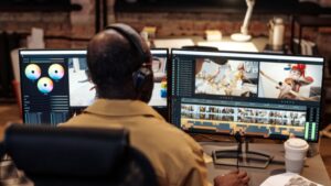 Person works on dual monitors to edit video and visuals as part of modern content creation workflow