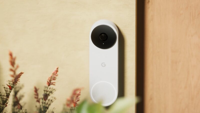 Google Nest wired doorbell mounted beside a front door with a clear camera lens and button visible