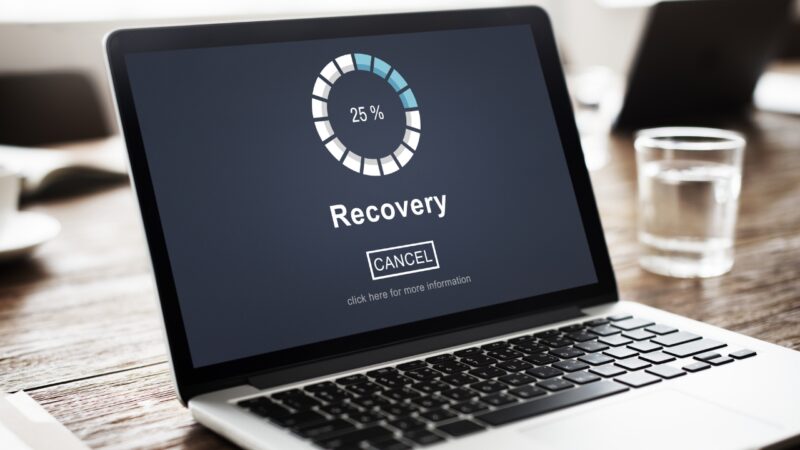 Laptop screen showing a data recovery progress bar at 25 percent